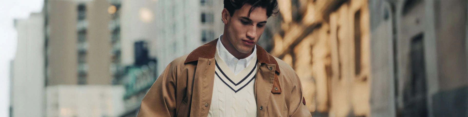 Casual old money outfit voor heren met beige jas, kabeltrui en wit overhemd in rustige kleuren