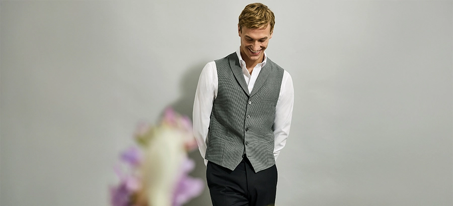 Mannelijke bruiloftsgast met wit overhemd en gilet als nette maar ingetogen outfit