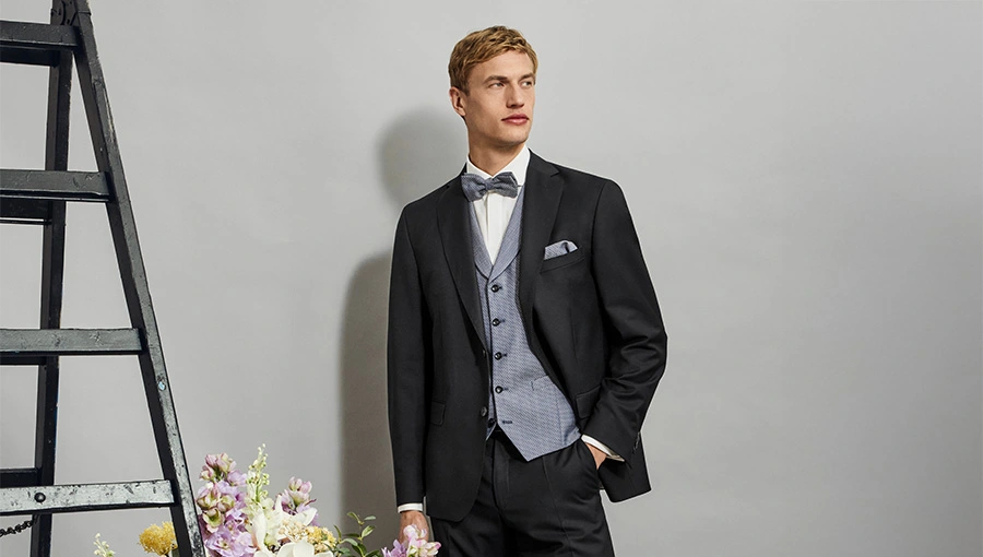 Donkere trouwbroek voor bruidegom als onderdeel van een klassiek driedelig trouwpak