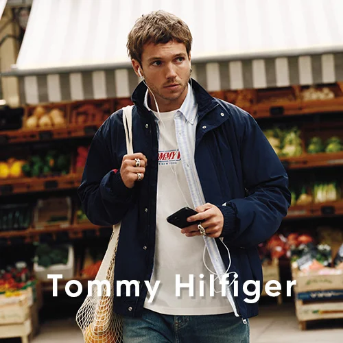 Man in marineblauw Tommy Hilfiger jack op een buitenmarkt