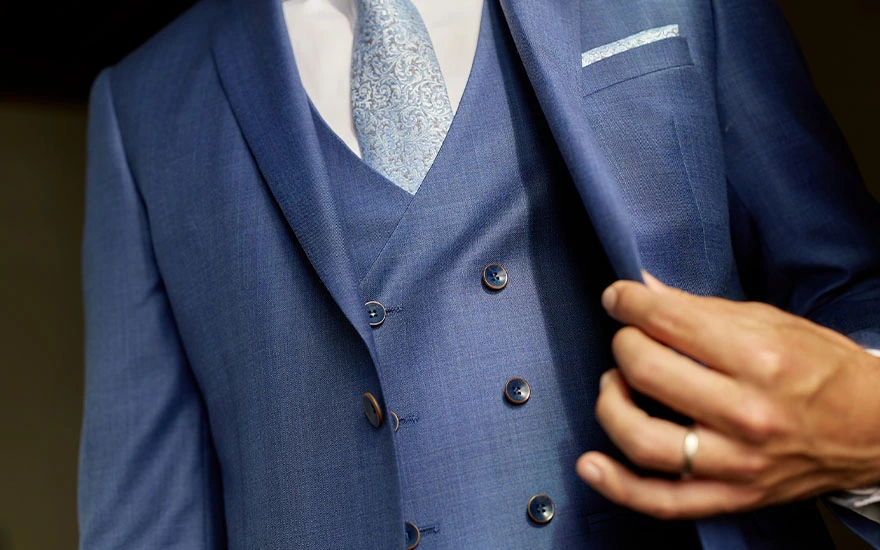 Detail van blauw trouwpak met gilet en lichtblauwe das